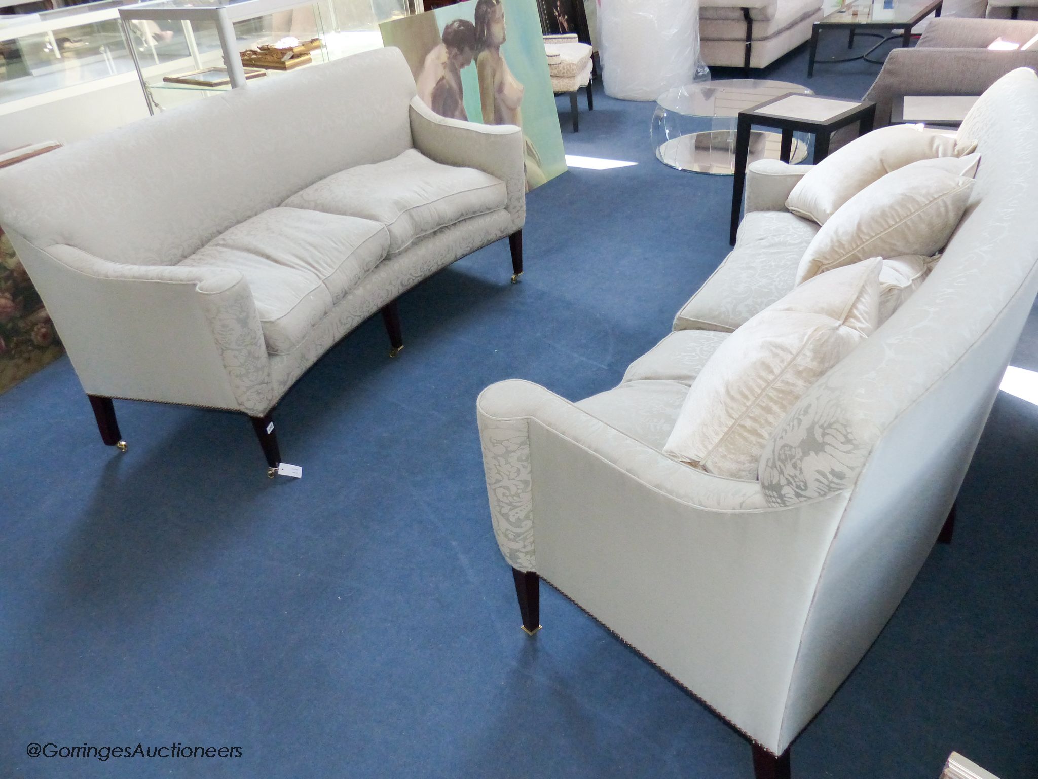 A pair of George III style eau de nil silk damask concave fronted two seat sofas, on square tapered mahogany legs with brass casters, approximately 188 cm wide